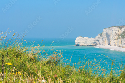 Picturesque landscape of natural cliffs and beach. La Porte d'Amont natural rock arch wonder. Coast of in sunny summer day, rocky ledges La Chaudron, Etretat, Normandy, France photo