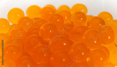 Orange gel round hydroponics balls in glass clear Cup on white background