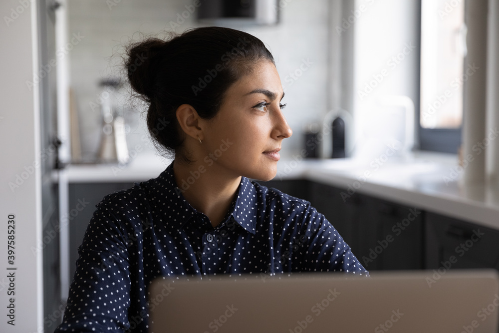 Visualizing work. Young indian woman remote employee working from home  distracted from laptop screen giving relax to eyes. Pensive hindu lady  student look at distance imagine good idea in more details Photos