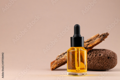 Beauty oil bottle with pipette on beige background