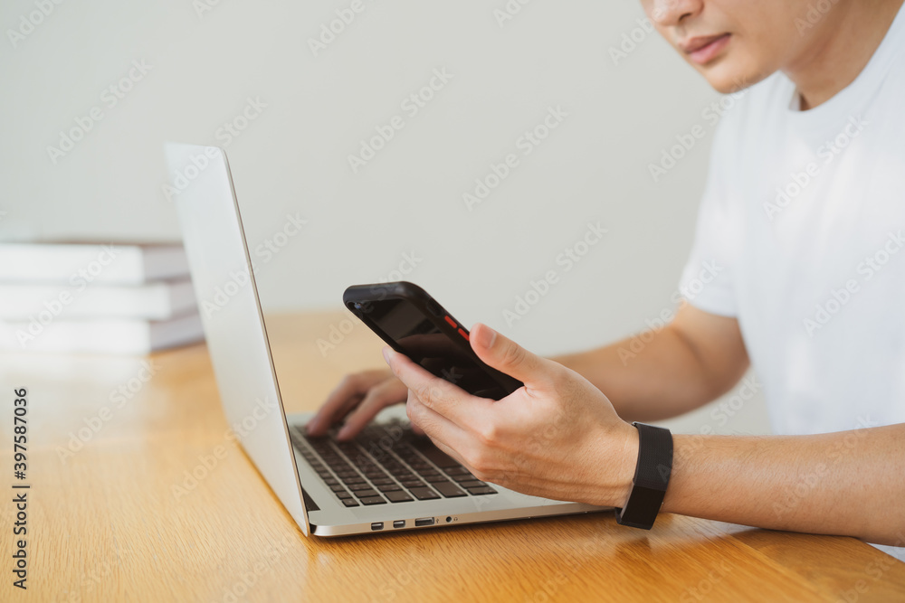 Naklejka premium Unrecognizable Asian young businessman working multi-tasking at home, work from home in new normal lifestyle.