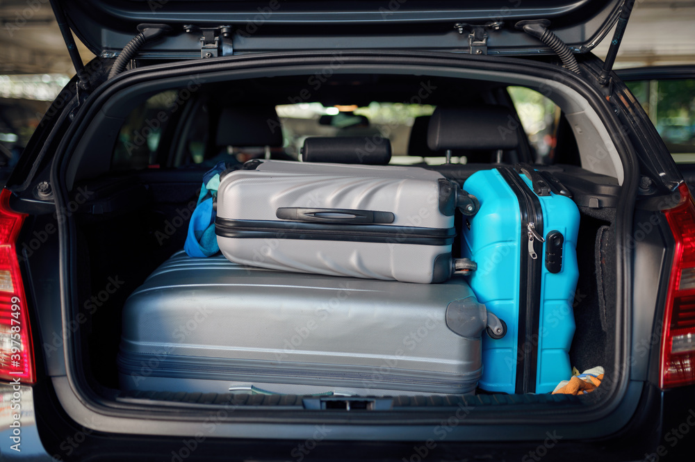 Suitcases in opened car trunk on parking, nobody Suitcases in opened car trunk on parking, nobody