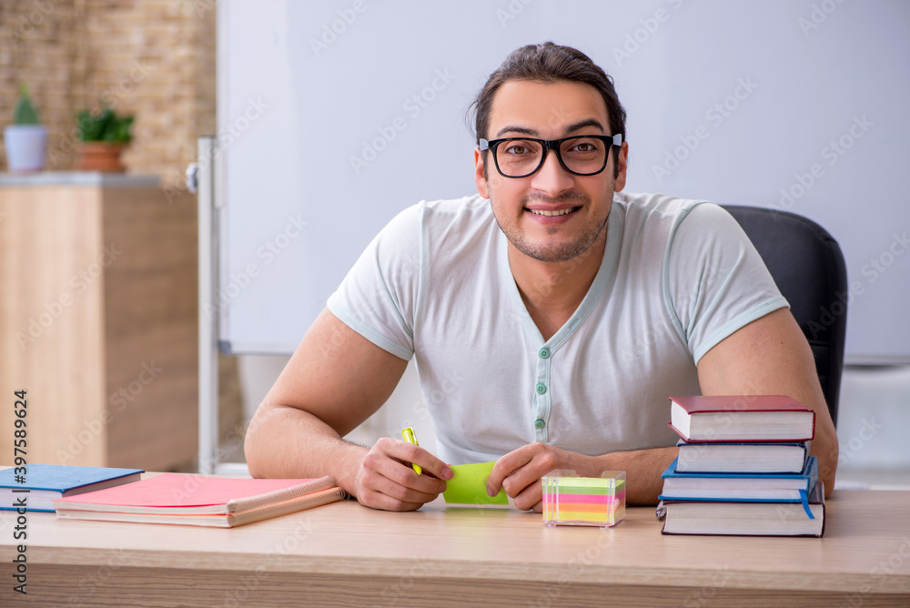 Young male teacher student sitting in the classroom Young male teacher student sitting in the classroom