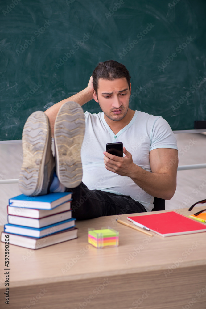 Young male teacher student sitting in the classroom Young male teacher student sitting in the classroom