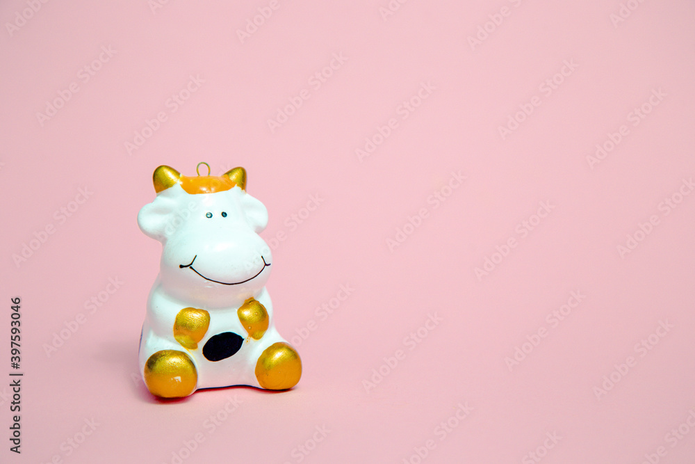 White bull is a symbol of 2021 according to the eastern calendar on a pink background. Holidays, winter and celebration concept. Merry Cristmas White bull is a symbol of 2021 according to the eastern calendar on a pink background. Holidays, winter and celebration concept. Merry Cristmas