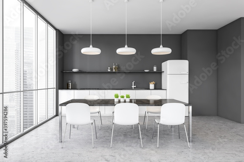 Grey and white kitchen set with fridge, chairs and dining table near window