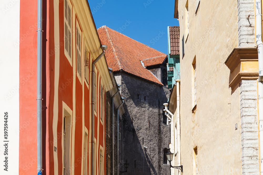 Old town street view. Walls and red tiled roofs. Sunny summer day.