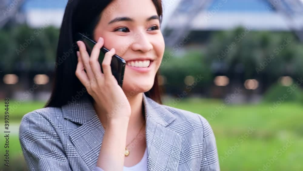 young asian woman is looking down at her mobile phone happily.female is browsing her smart phone with her head down outdoors.Business people talking phones.
young asian woman is looking down at her mobile phone happily.female is browsing her smart phone with her head down outdoors.Business people talking phones.