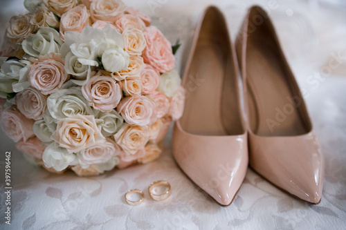 bride shoes with wedding gold rings and bouquet