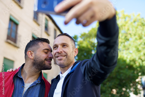 Gay couple making a selfie with their smartphone.