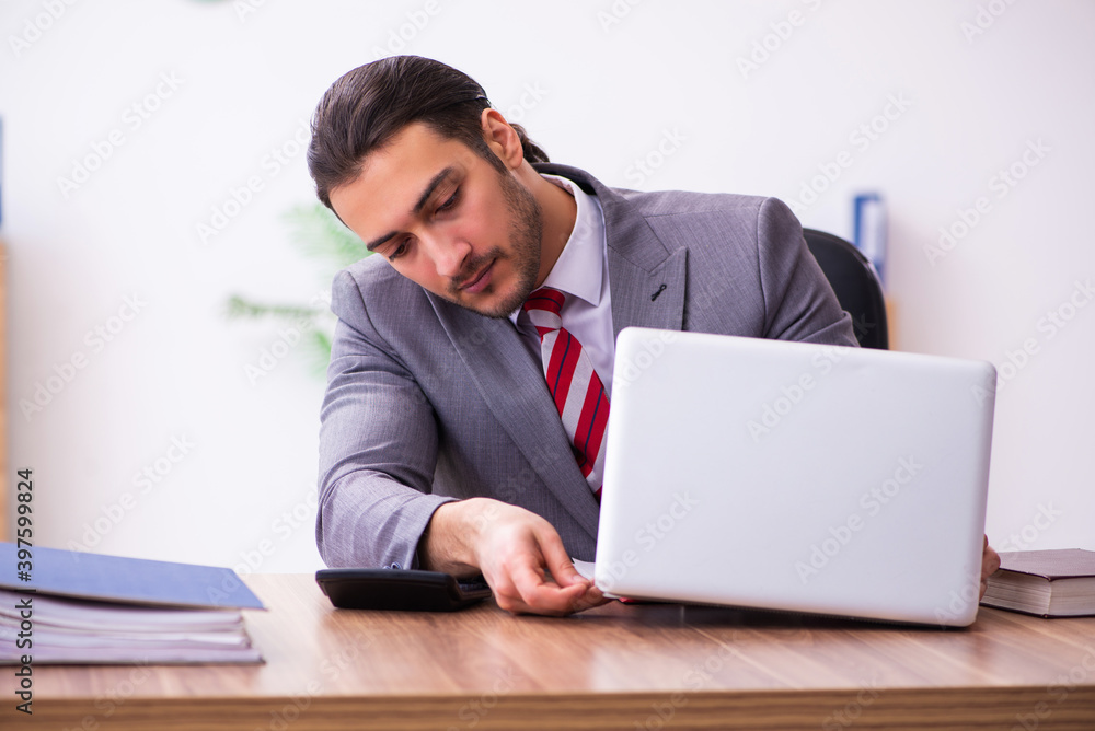 Young male employee inserting flash drive into laptop Young male employee inserting flash drive into laptop