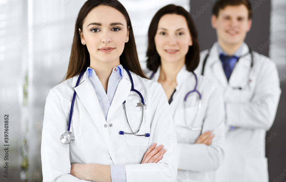 Group of young professional doctors is standing as a team with arms crossed in a hospital office and is ready to help patients. Medical help, insurance in health care, best disease treatment and Group of young professional doctors is standing as a team with arms crossed in a hospital office and is ready to help patients. Medical help, insurance in health care, best disease treatment and