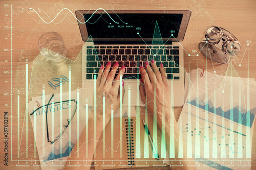 Double exposure of woman hands working on computer and forex graph hologram drawing. Top View. Financial analysis concept. © peshkova