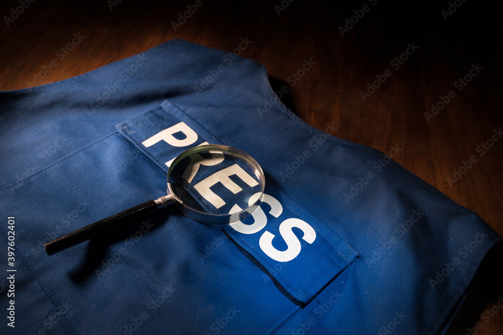 Media Journalism Global Daily News Content Concept. Blue journalist (press) vest in dark with backlight and fog. Media microphone on journalist vest.
