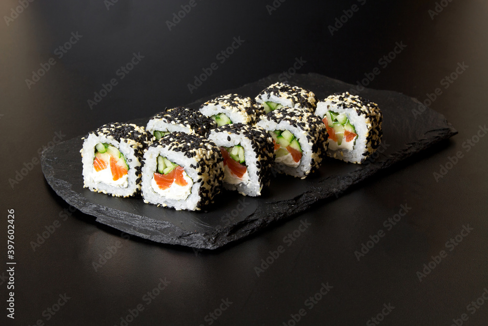Sushi rolls with sesame seeds on a stone Board for sushi Sushi rolls with sesame seeds on a stone Board for sushi