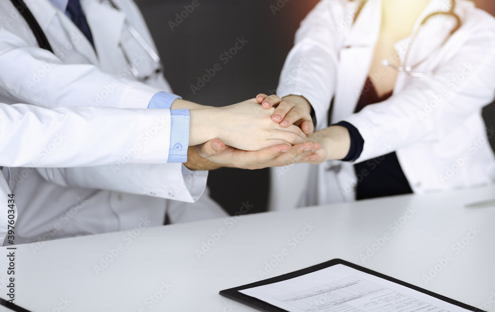Group of modern doctors joining hands as a circle. Teamwork in medicine during Coronavirus pandemic, covid 2019 Group of modern doctors joining hands as a circle. Teamwork in medicine during Coronavirus pandemic, covid 2019