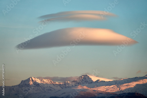 Large white lenticular clouds over Sierra Nevada  Spain  at sunset