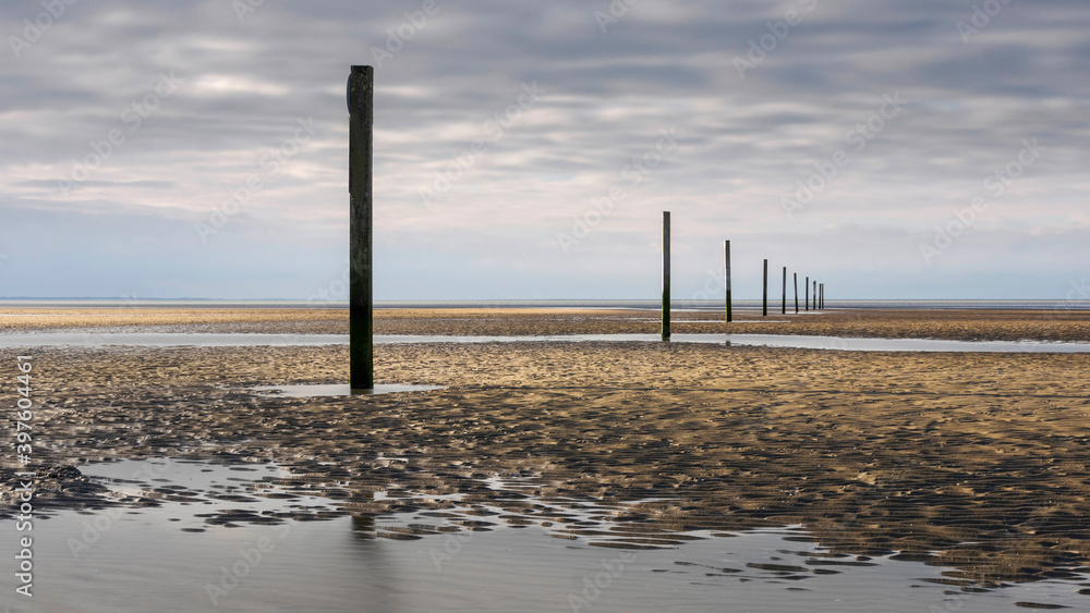 Scenic view of a row of posts on the beach on a winter day at the Oostvoorne beach