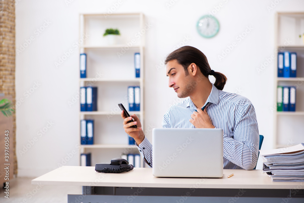 Young male employee working in the office Young male employee working in the office