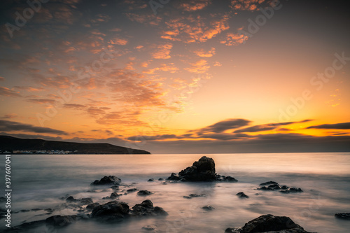 Sunrise or sunset in Fuerteventura Canary Islands. On the beach with stones and long exposure. unique light. Pure holiday feeling. fine clouds © Jan