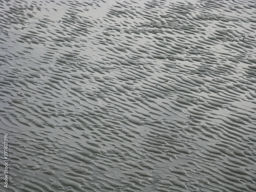 Ripples in an abstract pattern on sea bed over sand