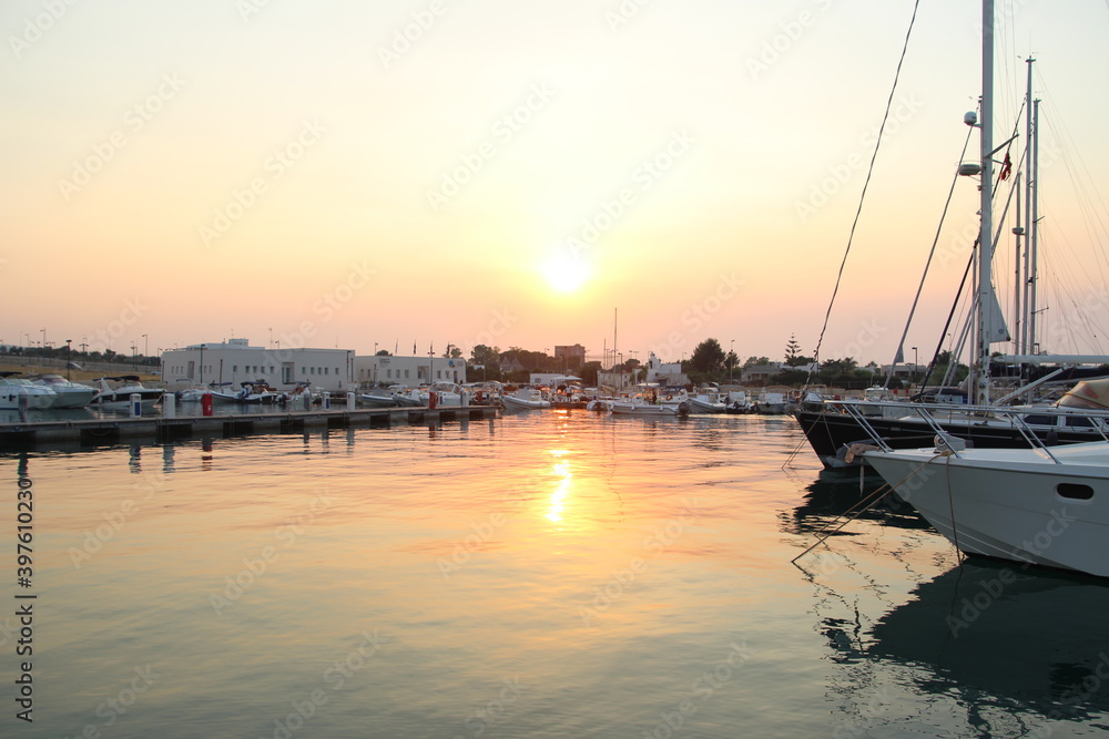 Sunset with boats over the old port in Apulia, Italy