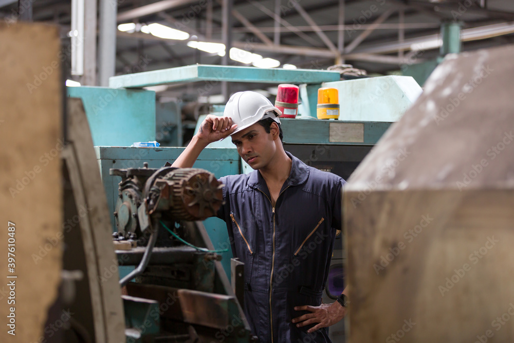 Portrait of male factory worker at work in the industry factory and wearing safety uniform and hard hat for protection Portrait of male factory worker at work in the industry factory and wearing safety uniform and hard hat for protection