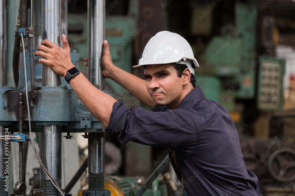 Professional male worker. Male engineer. Technical male factory worker working or maintenance with the machine in the industrial factory while wearing safety uniform and hard hat