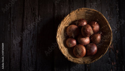 onions in basket on dark wooden table