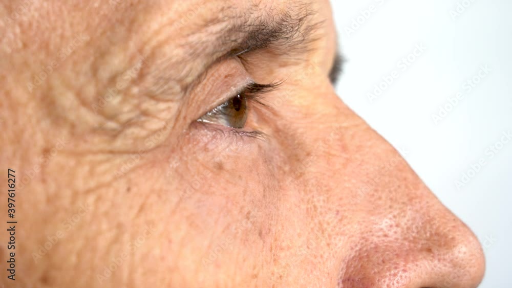 The older man's eye blinks. Face in profile. Close-up. The older man's eye blinks. Face in profile. Close-up.