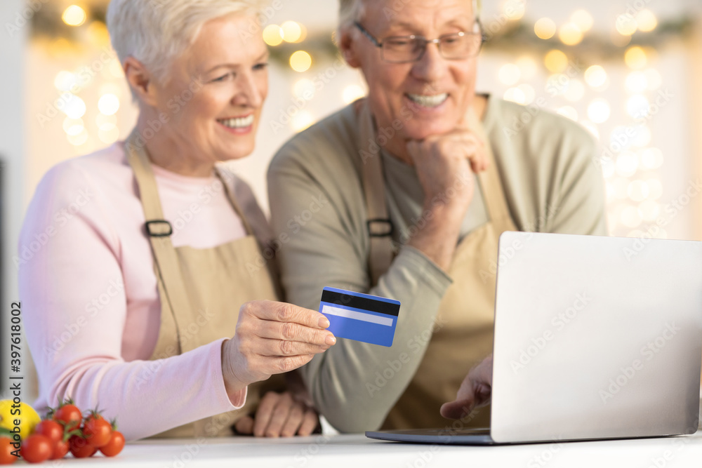 Senior Couple Using Laptop And Credit Card Ordering Food Indoor