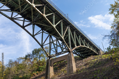 Fototapeta Naklejka Na Ścianę i Meble -  Hillside with concrete supports of an overhead arch bridge, fall season with blue sky, horizontal aspect