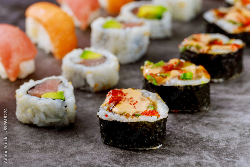 Sushi roll with raw fish on gray background. Japanese food. Sushi roll with raw fish on gray background. Japanese food.