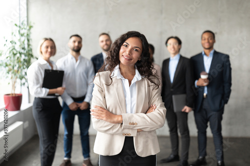 Businesswoman Standing In Front Of Her Employees Posing In Office