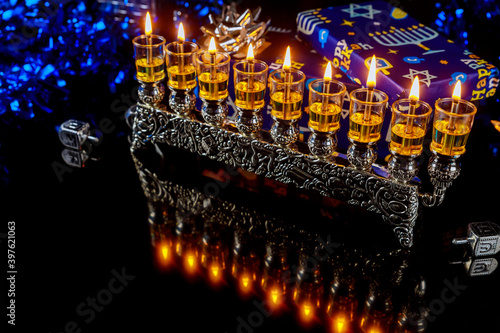 Menorah with oil candles and reflection on surface for Hanukkah jewish holiday.