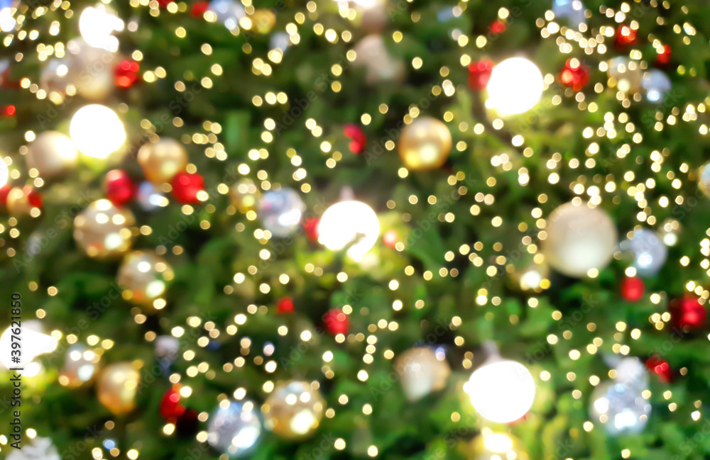 close up of defocused christmas tree with lights glowing. decorated christmas tree by shiny ornaments with glittering mood background. celebration concept background. close up of defocused christmas tree with lights glowing. decorated christmas tree by shiny ornaments with glittering mood background. celebration concept background.