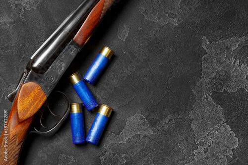 Fototapeta Close up of hunting shotgun and cartridges on dark grey background
