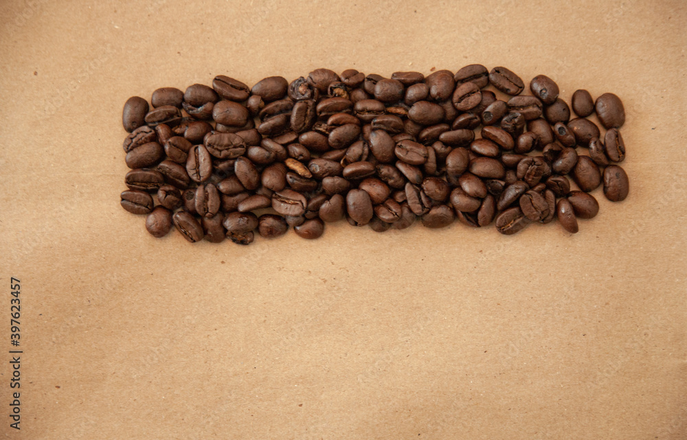 whole arabica coffee beans on a brown paper background whole arabica coffee beans on a brown paper background