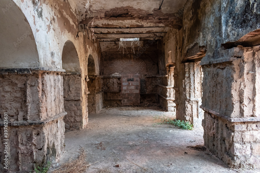 Bhopal, Madhya Pradesh, India - March 2019: Dilapidated columns inside an arcaded hall inside an ancient ruined building in the old city of Bhopal.