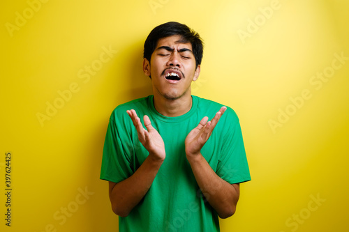 Young Asian man crying hard, loosing failure gesture
