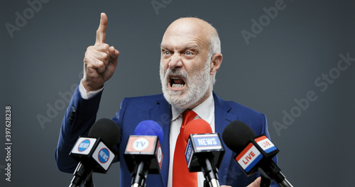 Photo Aggressive politician giving a speech at the press conference