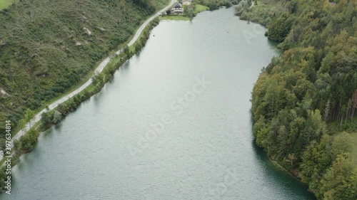 Freibach reservoir dam with the Stauseewirt Greek specialty restaurant at the far edge, Aerial tilt up reveal shot photo