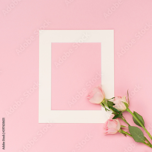 Pink flowers roses and empty frame on pastel pink background. Valentines day concept. Flat lay, top view, copy space. © Iuliia Metkalova