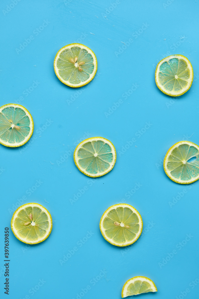 Composition with cut citrus fruits on blue background. Creative summer background composition with lemon slices. Minimal top down lemonade drink concept.Top view Composition with cut citrus fruits on blue background. Creative summer background composition with lemon slices. Minimal top down lemonade drink concept.Top view