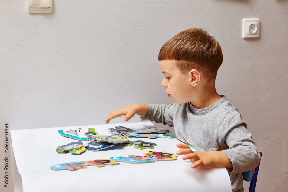 Child playing with puzzles,. The boy is playing in his room. Educational logic toys for kid's..