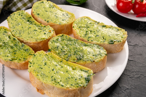 Traditional French appetizer. Baguette toast with green butter and pesto sauce.