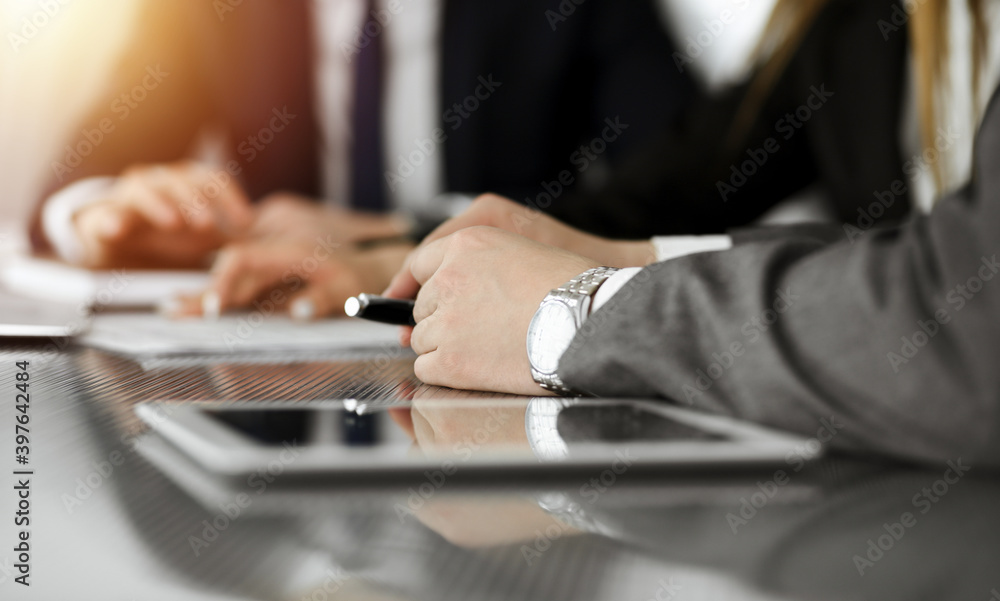 Unknown businessmen and woman sitting, using laptop computer and discussing questions at meeting in sunny office, close-up. Success concept Unknown businessmen and woman sitting, using laptop computer and discussing questions at meeting in sunny office, close-up. Success concept