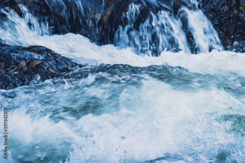 Stormy stream among rocks and boulders. Mountain river.