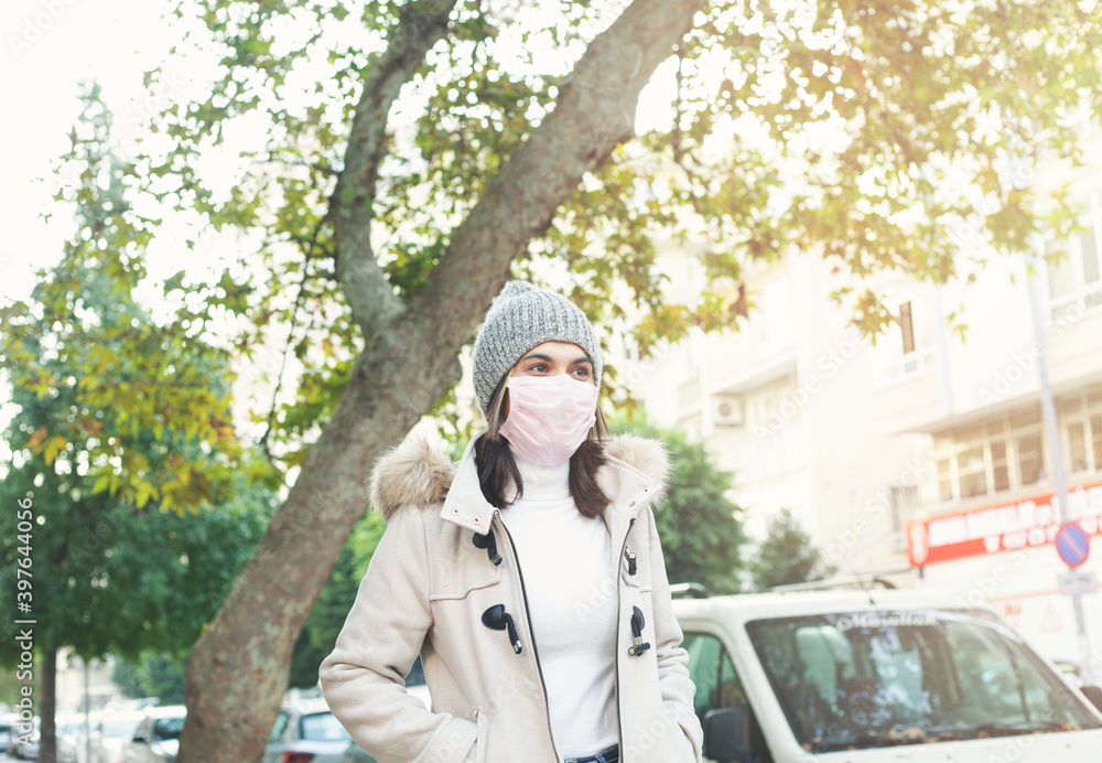 Fototapeta premium Young woman wearing a mask on street. 