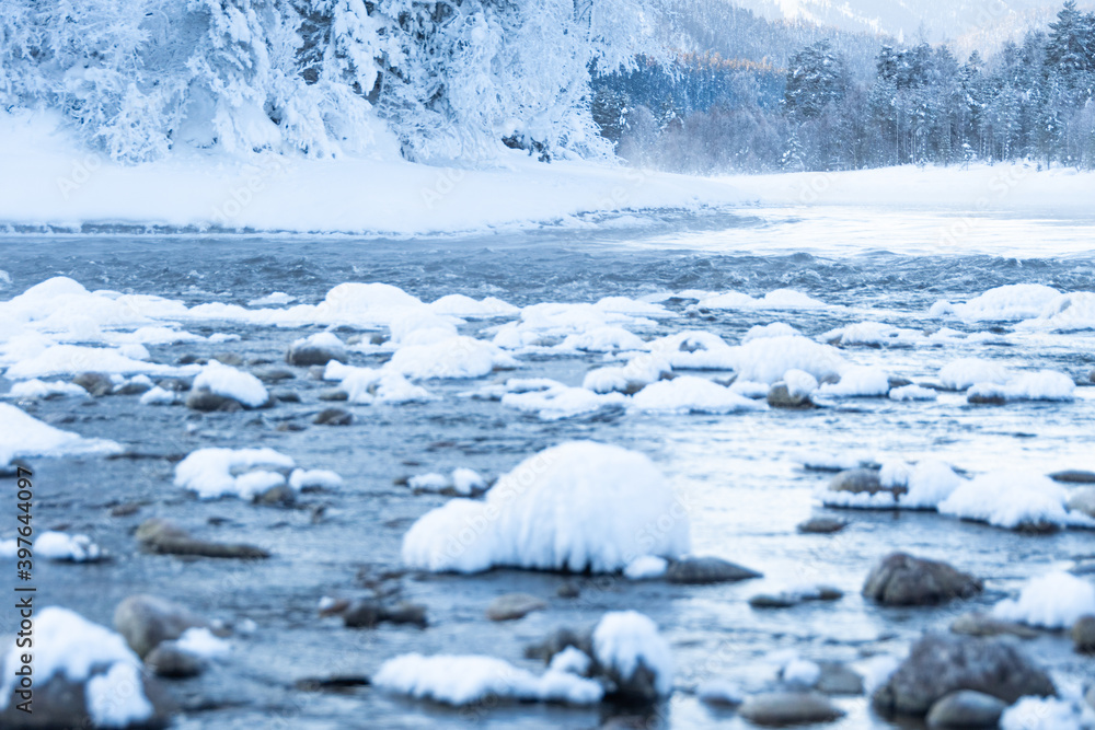 Boulders in cold water are covered with snow. Winter river on frosty morning. Boulders in cold water are covered with snow. Winter river on frosty morning.